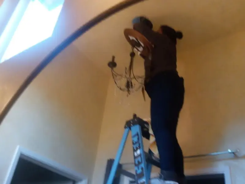 Electrician installing a chandelier in a Emporia residence